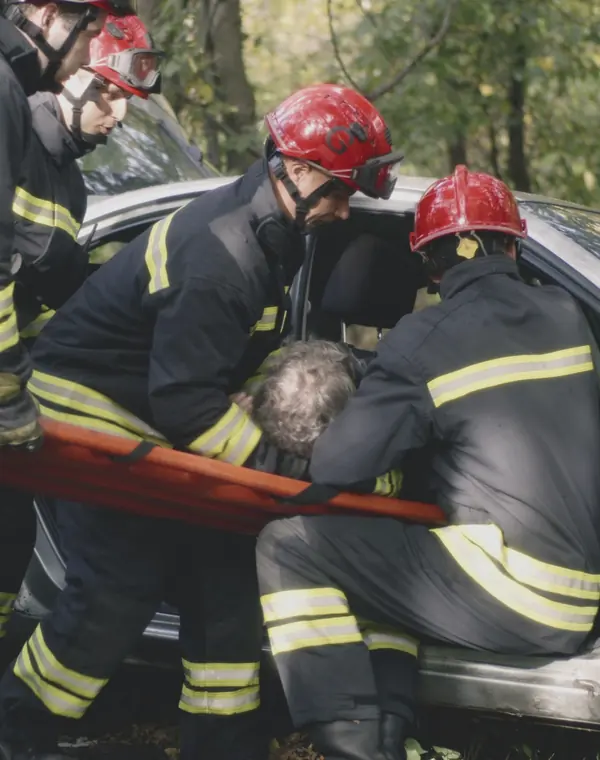 Firefighters rescuing a driver from a wrecked car